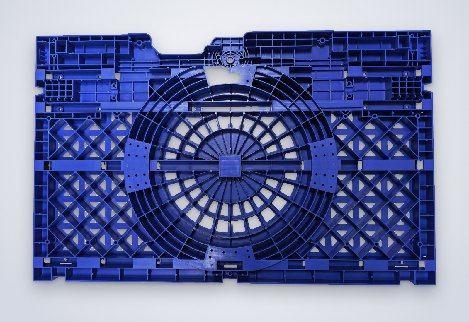 Large blue injection-molded base plate with radial and lattice ribbing, seen from below