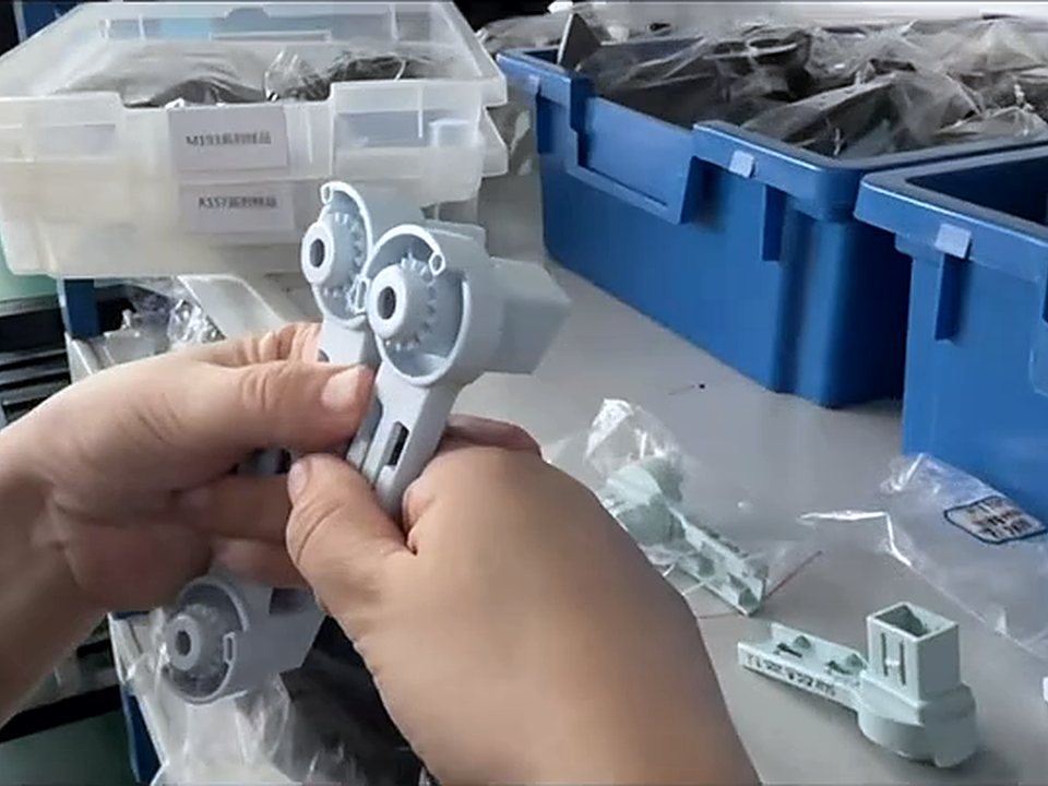双手对照样品检查灰色注塑件